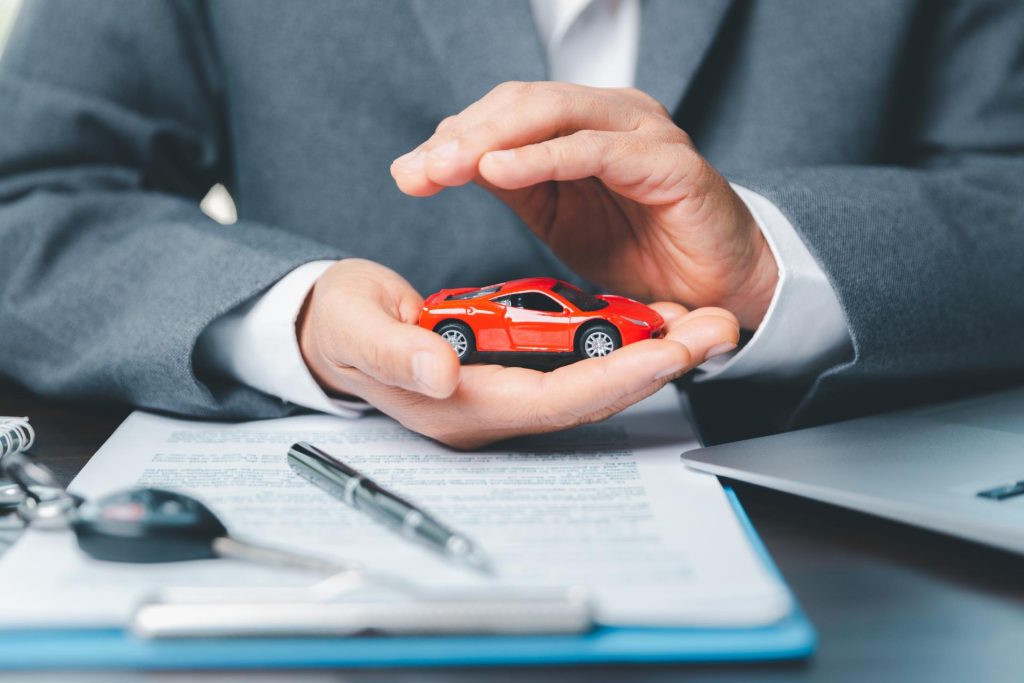 Car dealer holding miniature car in his office